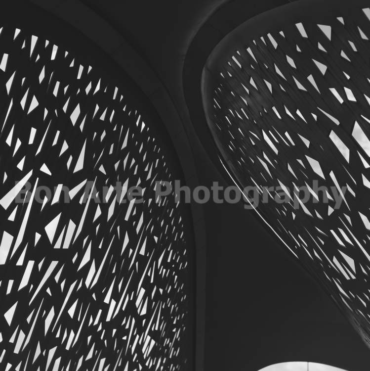 abstract geometric architecture album cover bon arte photography A minimalist square composition of a modern architectural structure featuring a complex lattice pattern of geometric cutouts with light passing through, ideal for electronic music album artwork.