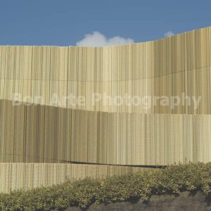 Abstract modern gold facade with vertical lines against a blue sky for electronic music album cover design by Bon Arte Photography.